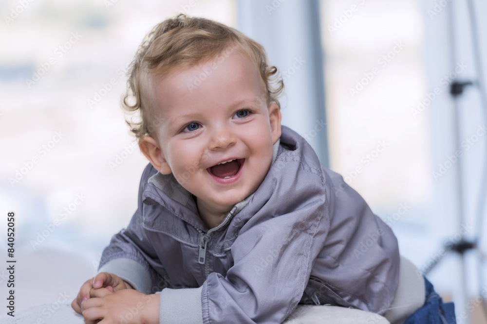 Portrait of a laughing baby, leaning against a chair Portrait of a laughing baby, leaning against a chair