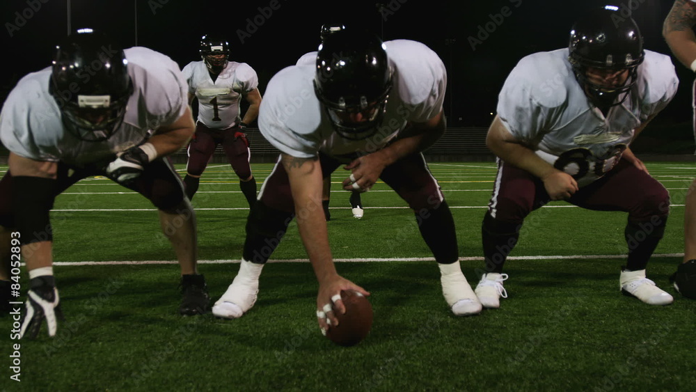 A football team sets up at the line of scrimmage and hikes the ball A football team sets up at the line of scrimmage and hikes the ball