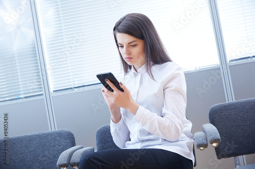 business woman with mobile phone sits in the office