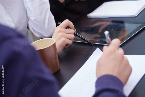 hand a group of businessmen on a table with a tablet  mobile pho
