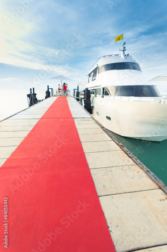 Yacht docking at the pier with red carpet to party