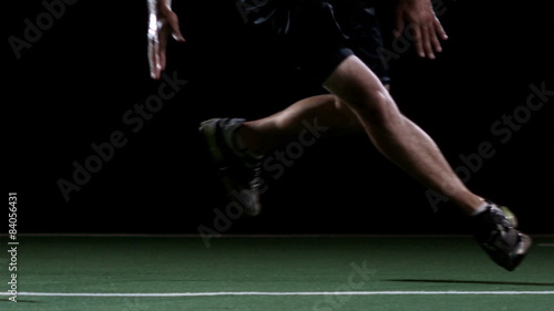 A male athlete runs back and forth between some cones photo