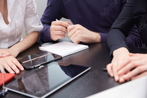 hand a group of businessmen on a table with a tablet, mobile pho