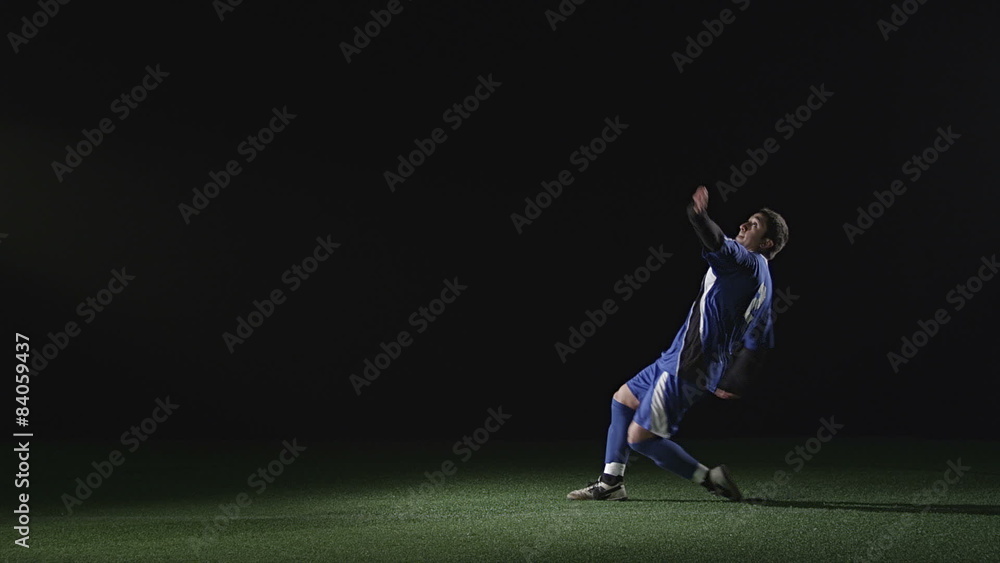 A soccer player does a bicycle kick on a black background A soccer player does a bicycle kick on a black background