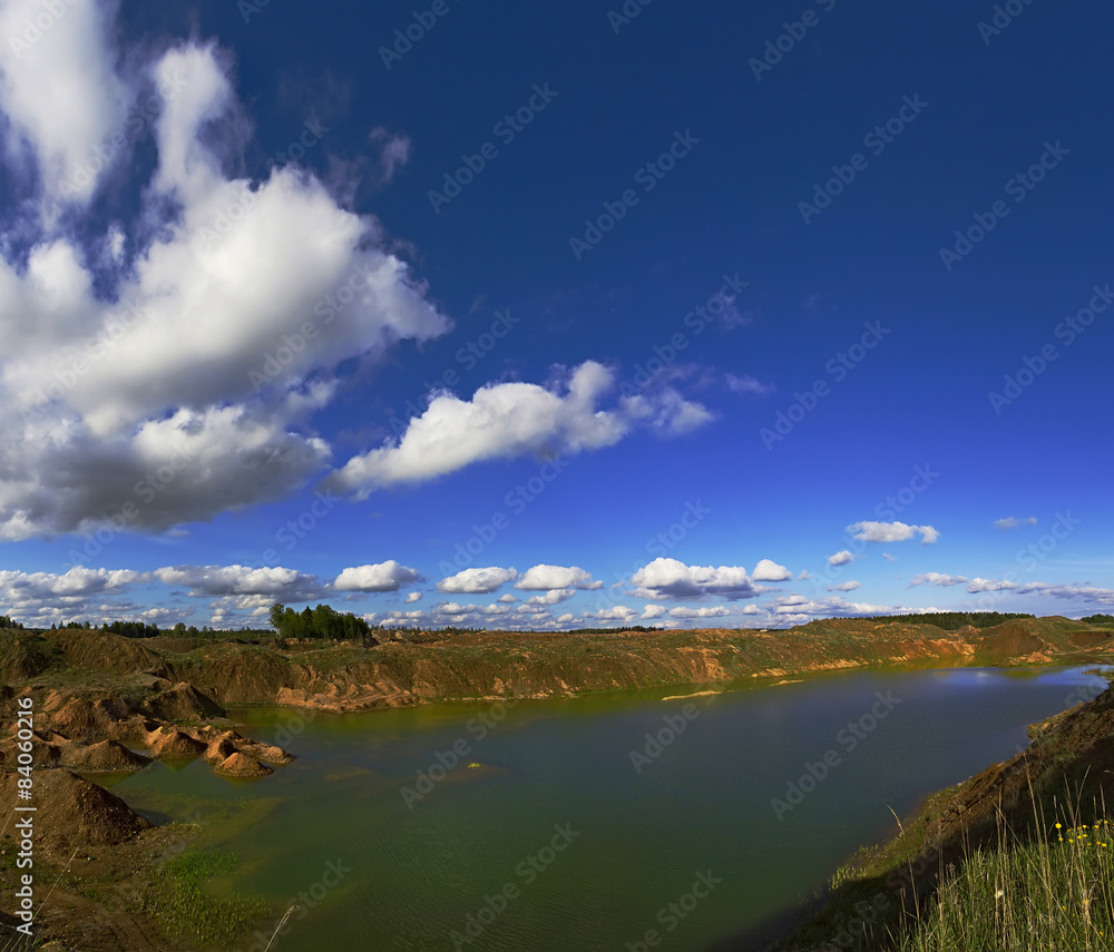 abandoned quarry, blue sky and white clouds.