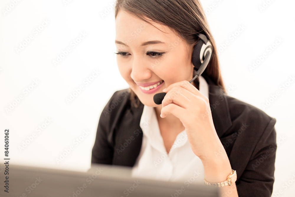 businesswoman talking on the phone while working on her computer businesswoman talking on the phone while working on her computer