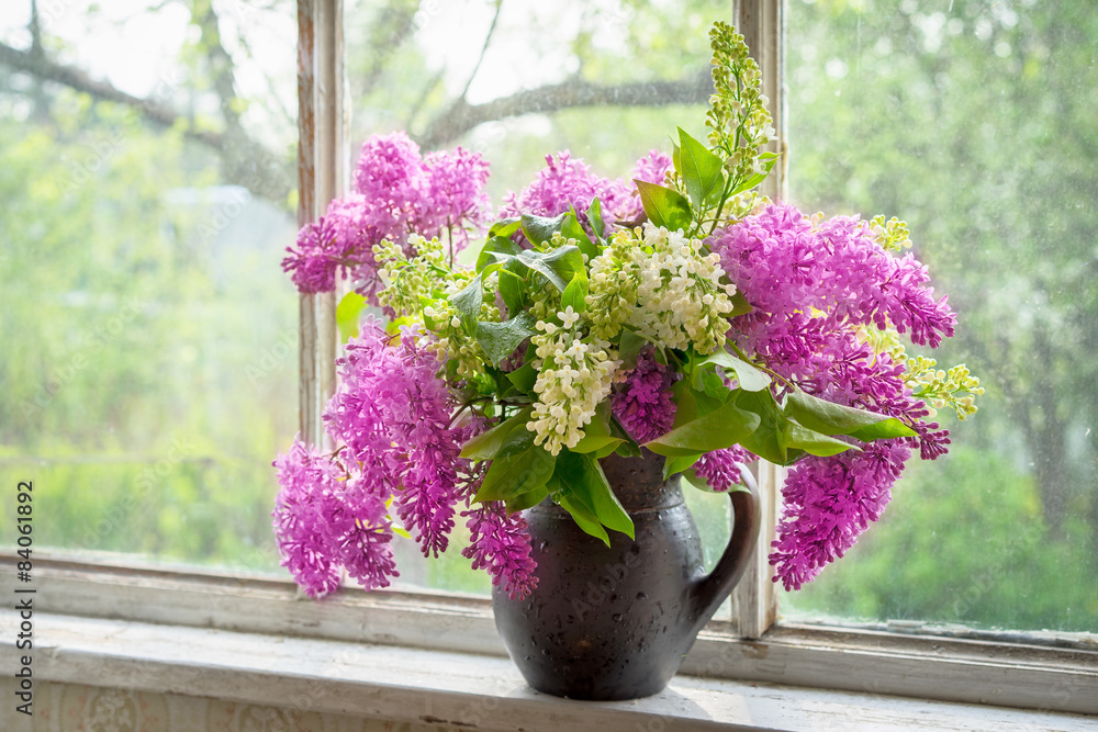 bouquet of lilac in a brown clay vase on a window sill bouquet of lilac in a brown clay vase on a window sill