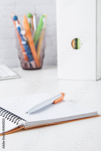orange ball pen with notebook
