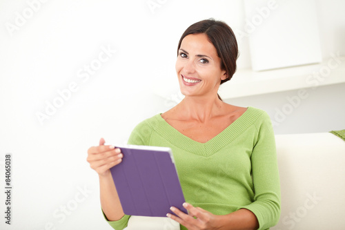 Beautiful lady holding a tablet indoors