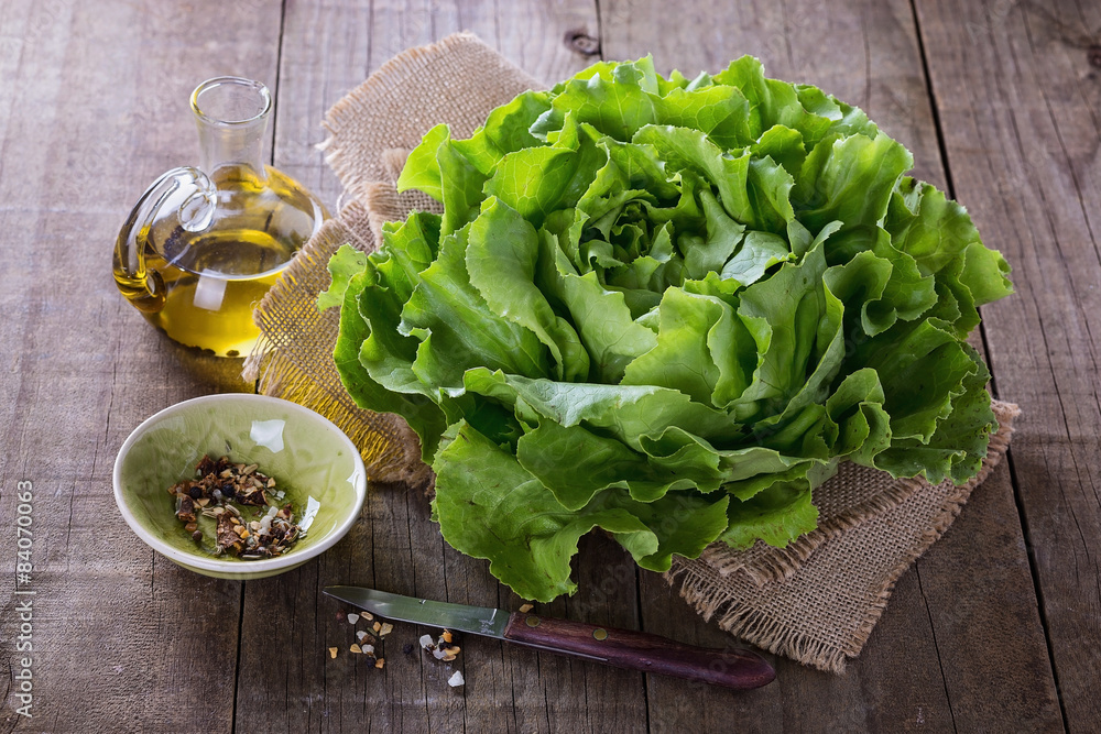 Butter lettuce and oil over rustic background - obrazy, fototapety, plakaty 