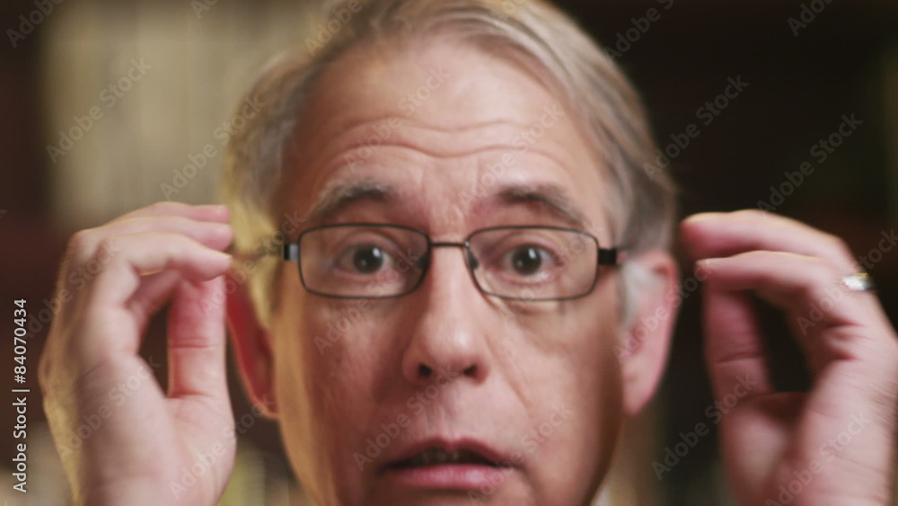 A older man talking and taking off his glasses over a video chat. Close up shot A older man talking and taking off his glasses over a video chat. Close up shot