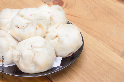 Chinese steamed buns on wood background.