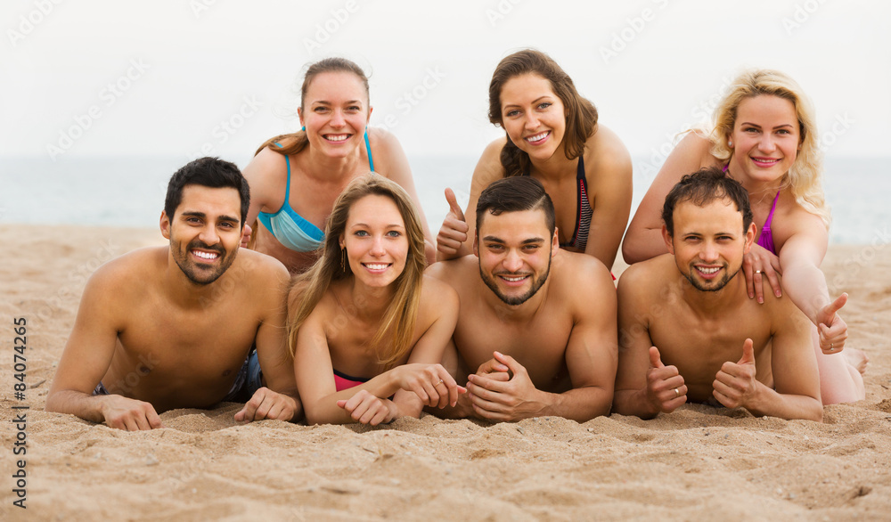 Friends laying on sand at beach