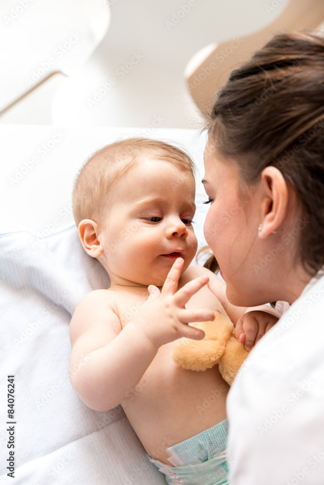 Mother playing with her baby on the bed at home. Mother playing with her baby on the bed at home.