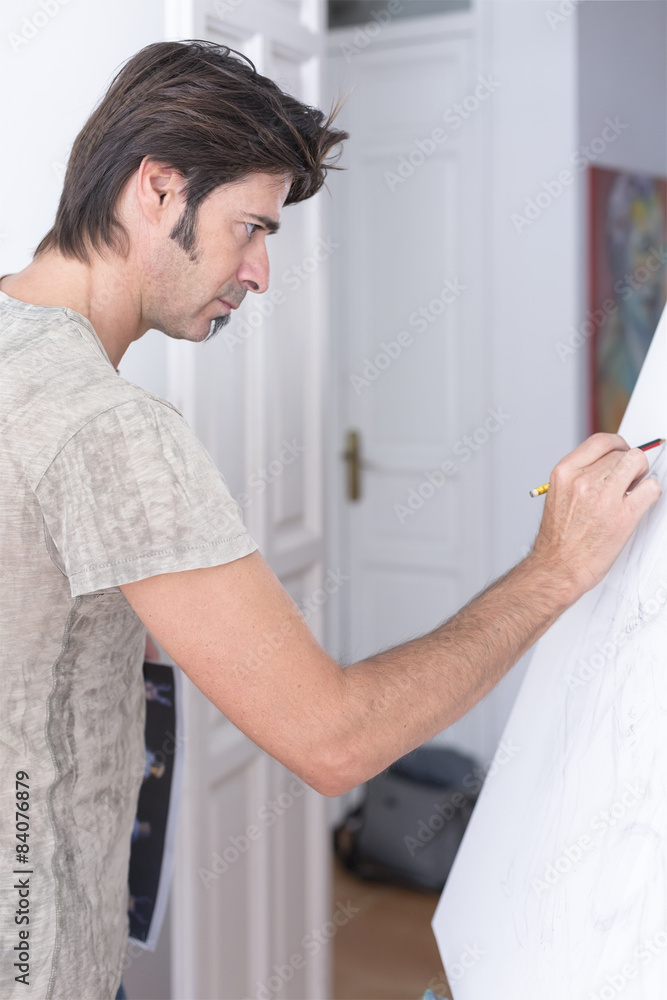 young man drawing on canvas - painting session. young man drawing on canvas - painting session.