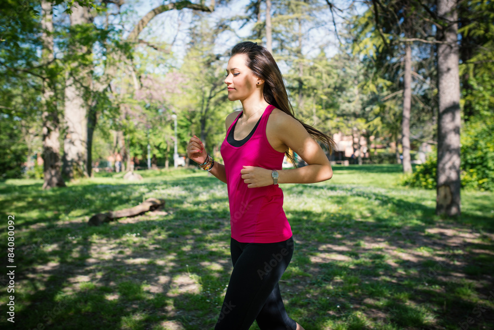 Young beautiful woman running outdoors in a park. Young beautiful woman running outdoors in a park.