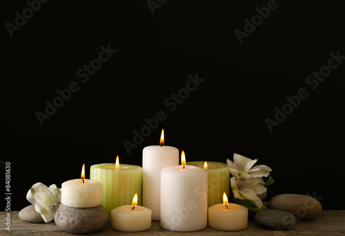 Beautiful composition with candles and spa stones on dark background