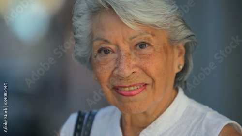 Close up shot of an old Spanish lady looking into the camera and smiling