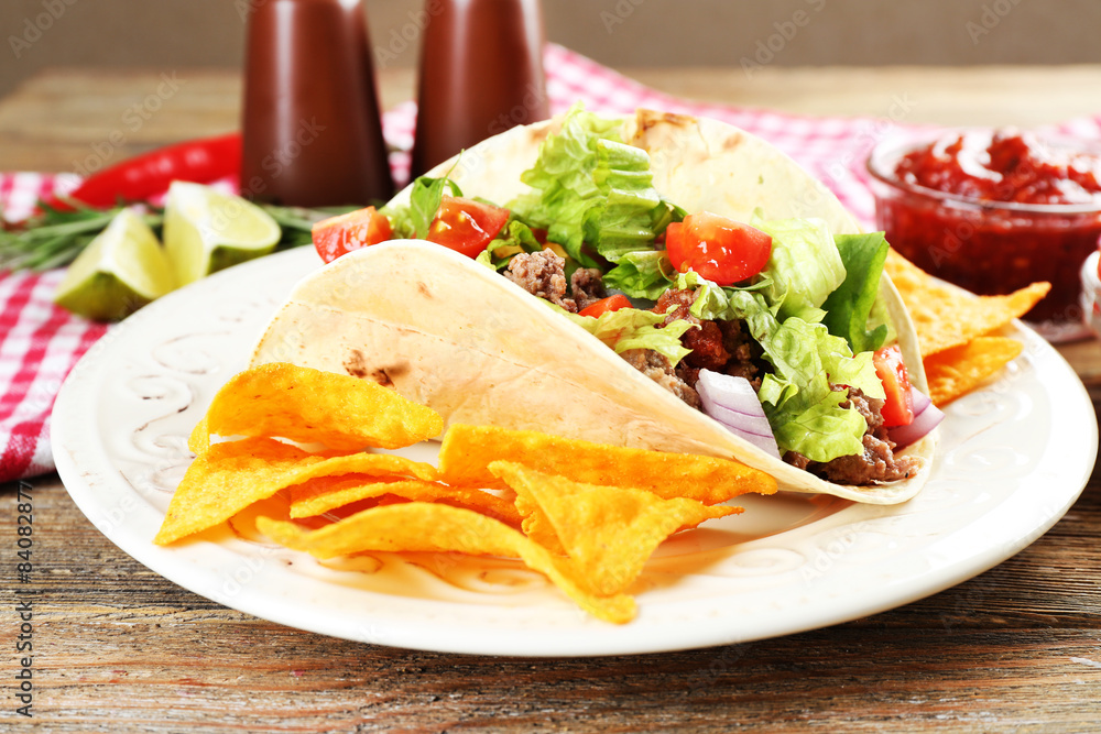 Mexican food Taco in plate on wooden table, closeup Mexican food Taco in plate on wooden table, closeup