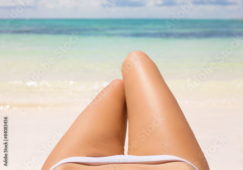Slim woman's legs on the beach