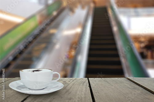 Blur background and terrace wood with escalator in shopping mall photo