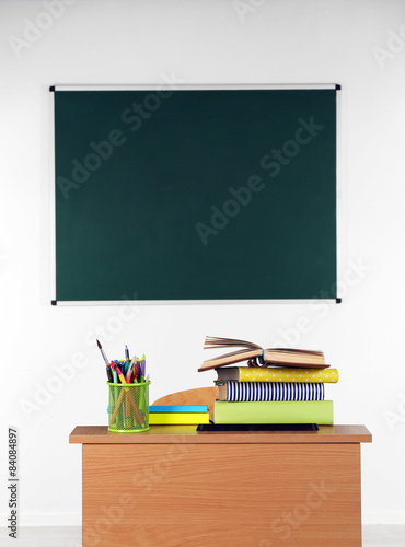 Wooden desk with stationery and chair in class 