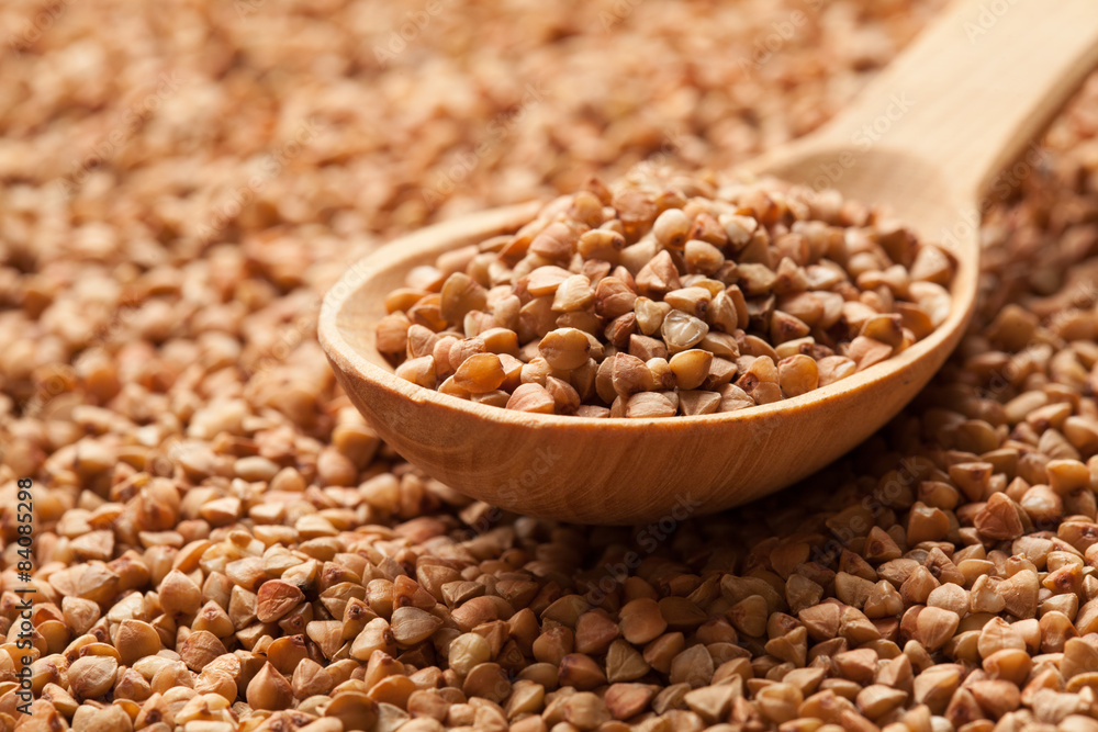 Wooden spoon on scattered buckwheat. Wooden spoon on scattered buckwheat.