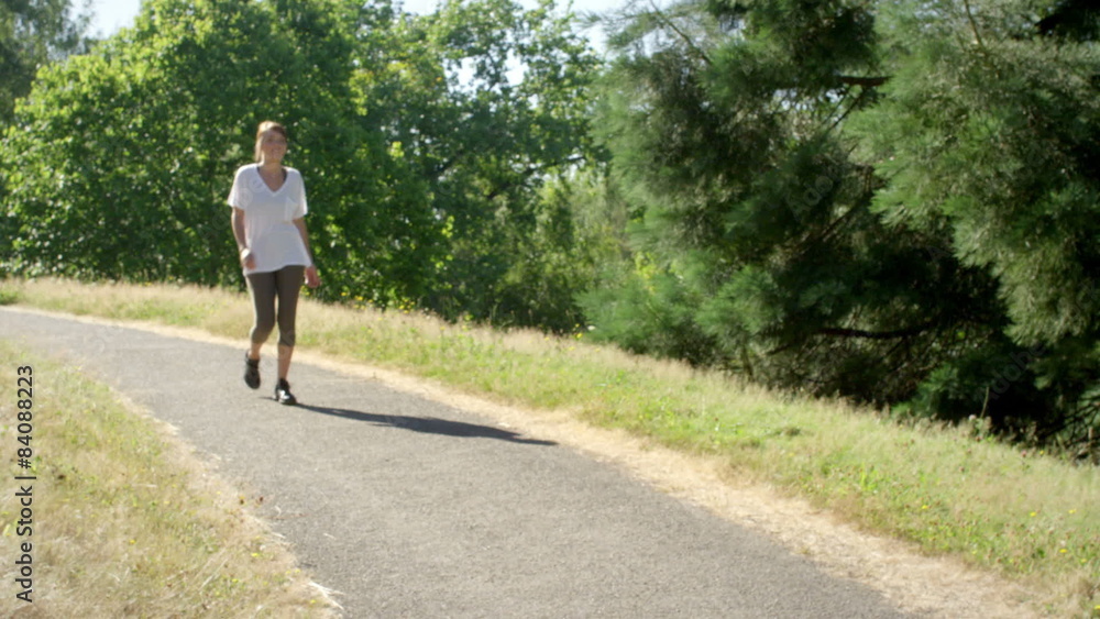 Fit and healthy young woman walks through the park Fit and healthy young woman walks through the park