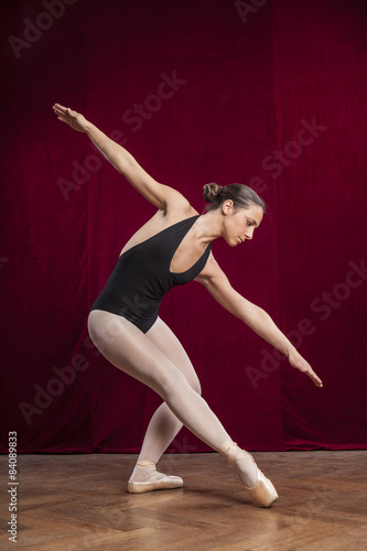young beautiful ballet dancer on red velvet background