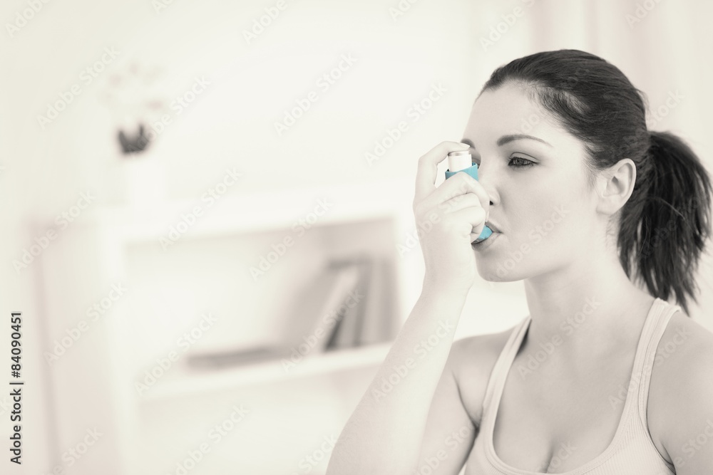 Woman using asthma inhaler in living room Woman using asthma inhaler in living room