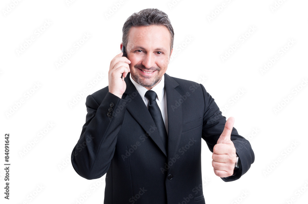 Business man talking on the phone and showing thumb up Business man talking on the phone and showing thumb up