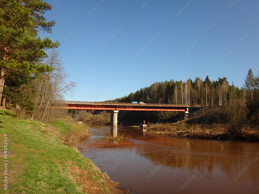 Мост через разлившуюся реку с коричневой водой