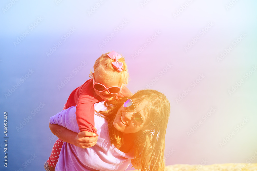 mother and little daughter play on sky
