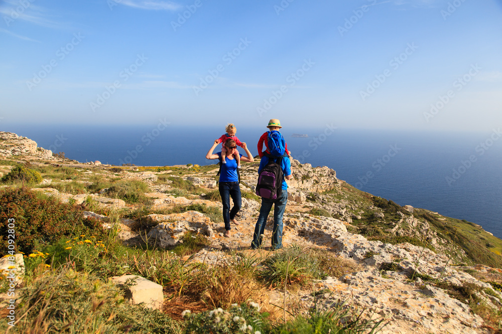 family with kids hiking in summer mountains