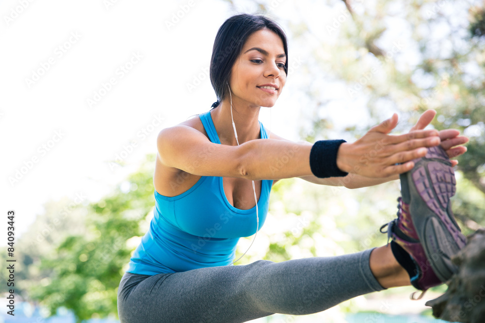 Sporty woman stretching legs in park Sporty woman stretching legs in park