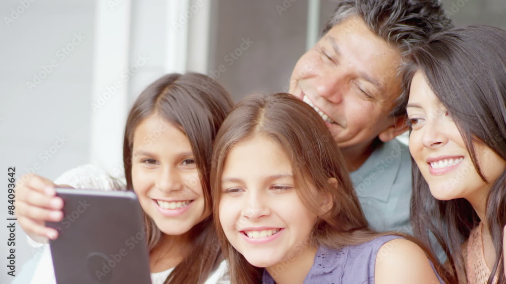 A family sits on a bench and takes a selfie with a tablet A family sits on a bench and takes a selfie with a tablet