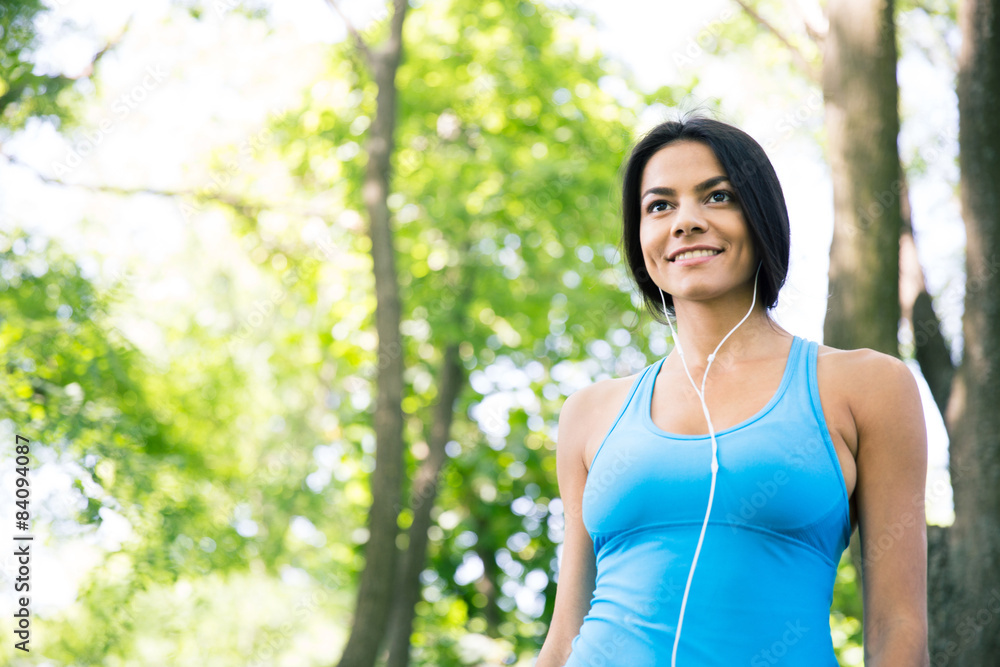 Smiling sports woman in headphones outdoors Smiling sports woman in headphones outdoors
