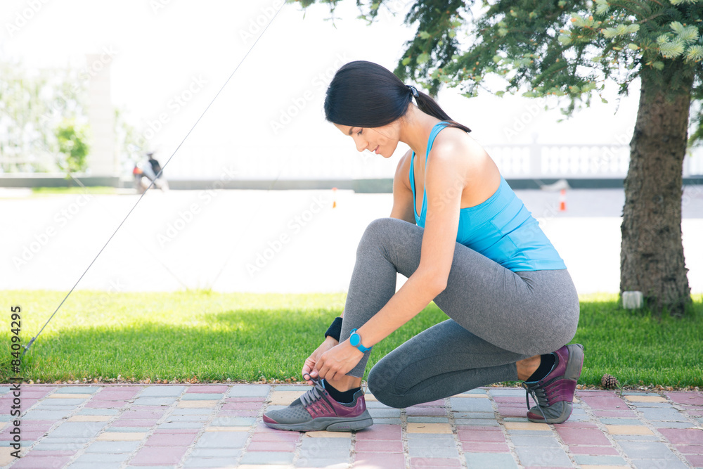 Woman tying her shoelace outdoors