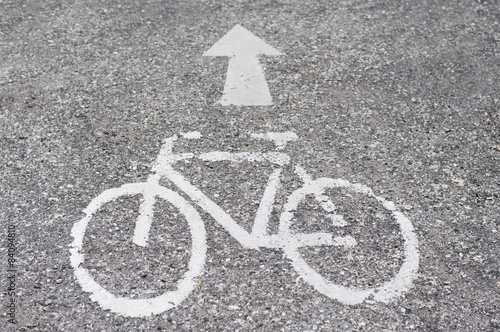 Strasse mit weissem Pfeil und Fahrradsymbol