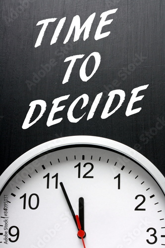 The phrase Time To Decide on a blackboard with a clock