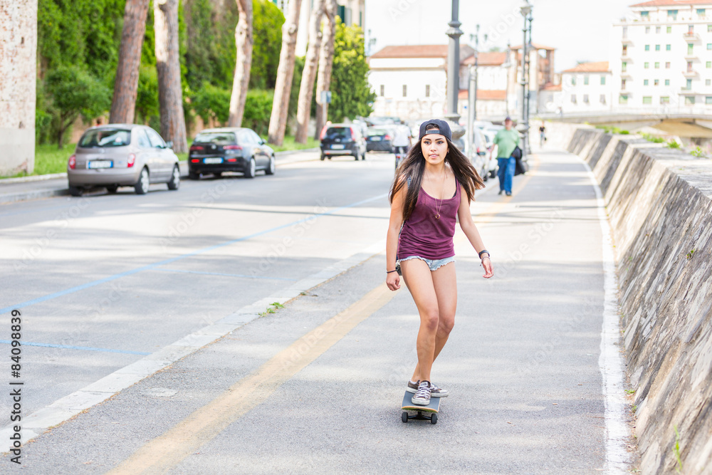 Beautiful mixed race girl skating in the city