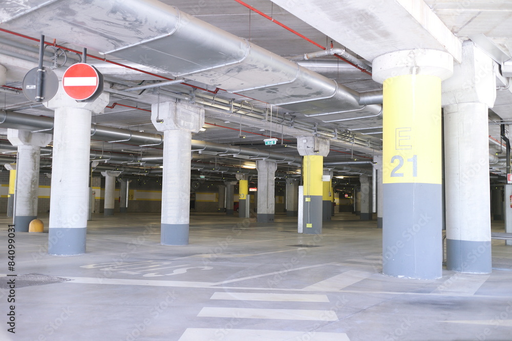 Fototapeta premium Underground park of a mall with columns and ventilation ducts