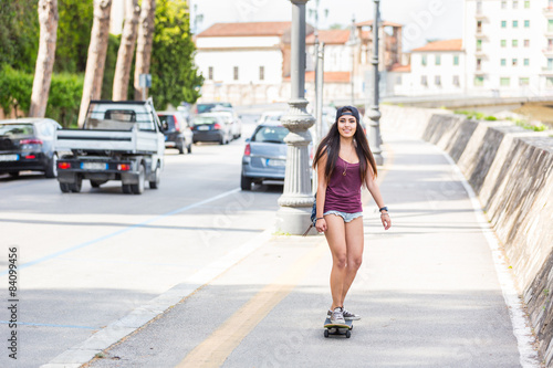 Beautiful mixed race girl skating in the city
