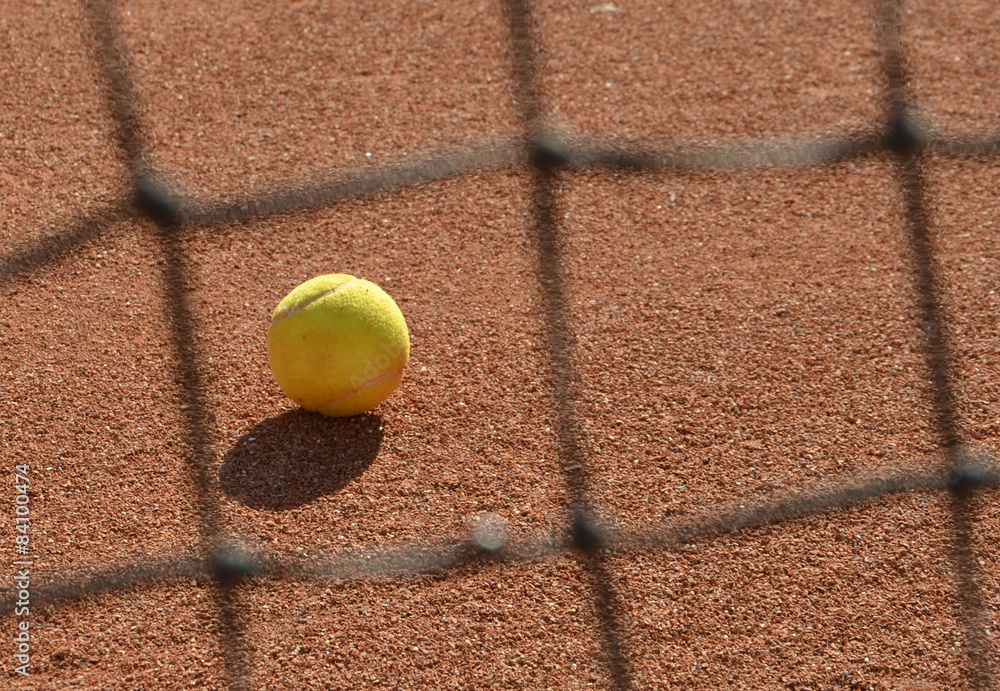 tennis ball photo through blurred tennis net