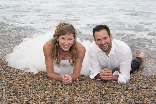 Newly married couple lying on the beach