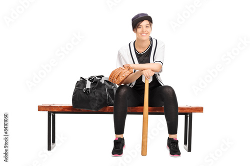 Female baseball player sitting on a bench