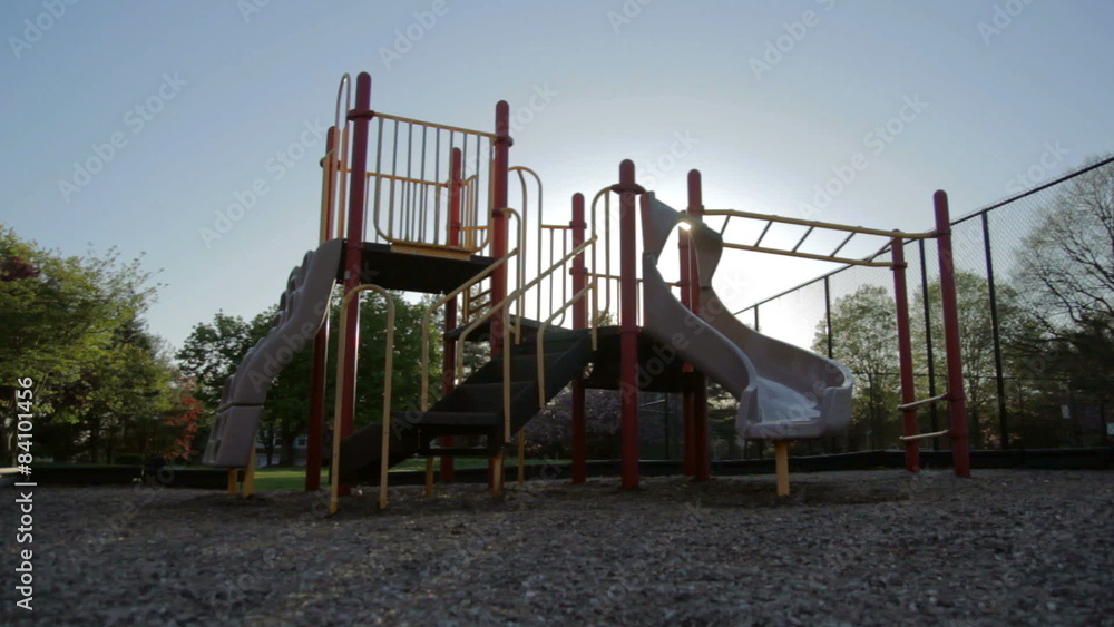 Dolly of an empty children's playground shilouetted as the sun sets. Dolly of an empty children's playground shilouetted as the sun sets.