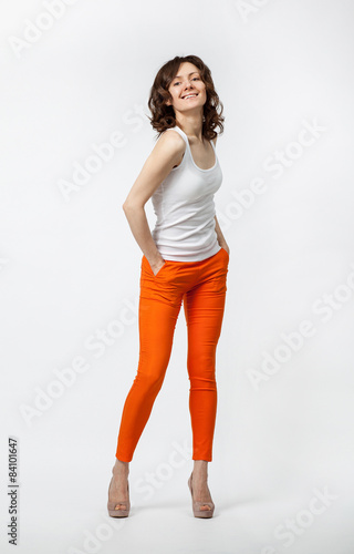 Wallpaper Mural Happy smiling young woman in orange pants posing on neutral back Torontodigital.ca