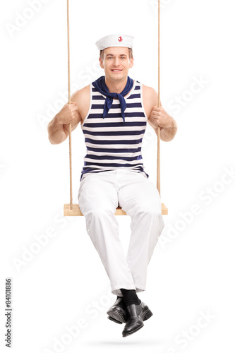 Young male sailor sitting a swing