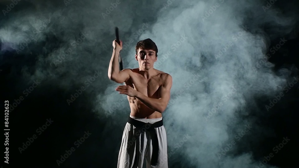 Karate man with a naked torso exercise with nunchaku. Slow Karate man with a naked torso exercise with nunchaku. Slow